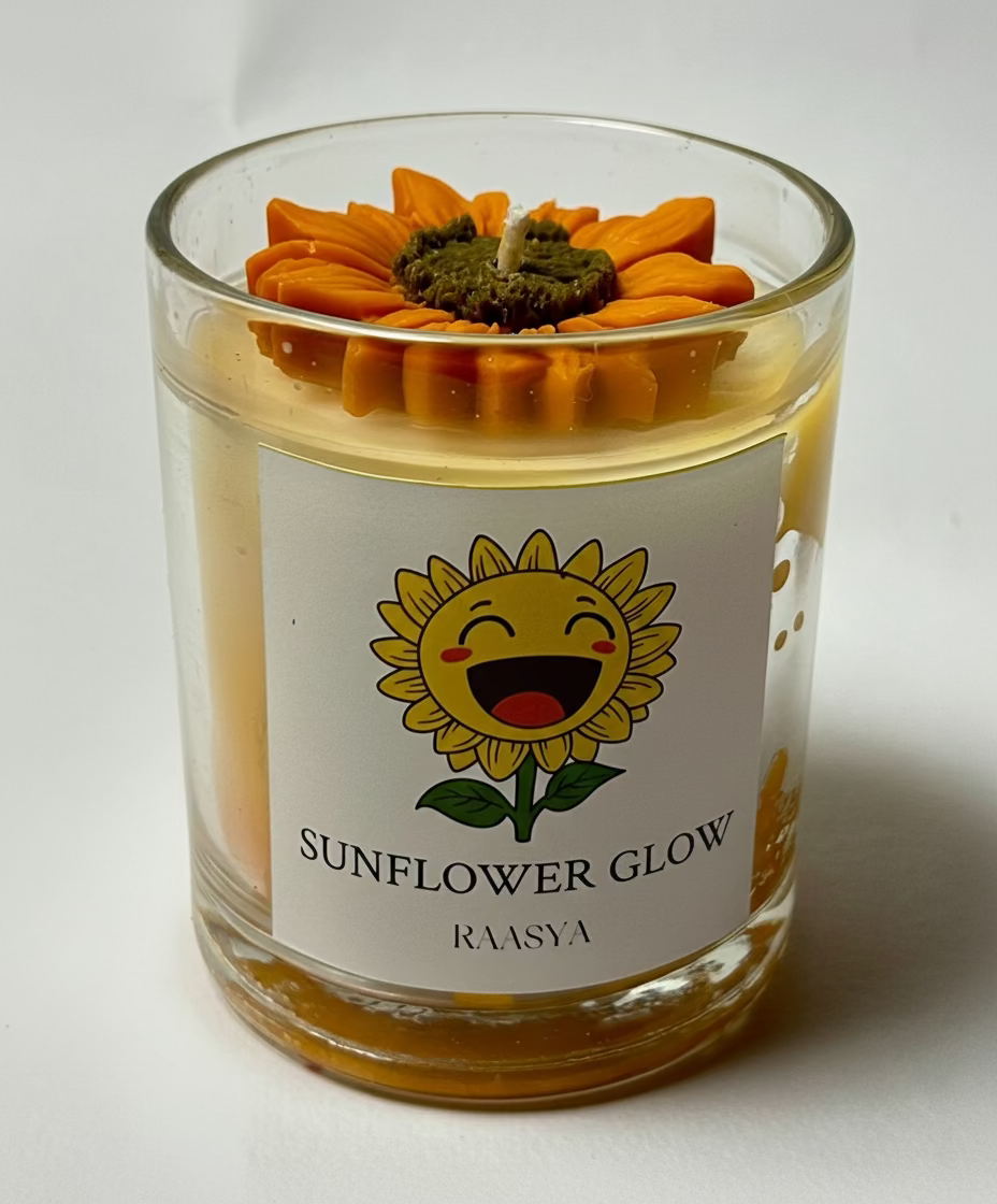 Candle in a glass jar with a sunflower-themed label on a white background
